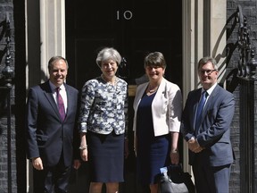 Britain's Prime Minister Theresa May, second left, greets Democratic Unionist Party (DUP) leader Arlene Foster, second right, DUP deputy leader Nigel Dodds, left, and member of parliament Jeffrey Donaldson, outside 10 Downing Street in London, Monday June 26, 2017. The leader of a Northern Ireland-based party is in London to finalize an agreement with Prime Minister Theresa May's Conservative-led government. (Dominic Lipinski/PA via AP)