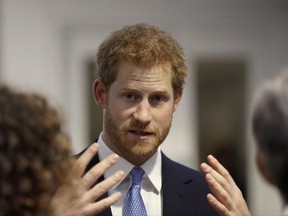 FILE - In this Thursday, June 15, 2017 file photo, Britain's Prince Harry speaks to people during his visit to Chatham House, the Royal Institute of International Affairs, in London. In an interview published on Sunday June 25, 2017 in The Mail on Sunday, the prince said the time he spent in the army was "the best escape I've ever had" and that he once considered giving up his title. He said: "I felt I wanted out, but then decided to stay in and work out a role for myself." (AP Photo/Matt Dunham, Pool, File)