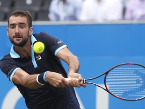 Marin Cilic of Croatia plays a return to Stefan Kozlov of the United States during day four of the Queen's Club tennis tournament in London, Thursday, June 22, 2017. (AP Photo/Kirsty Wigglesworth)