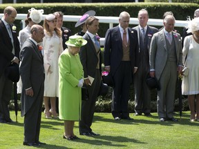 Britain's Queen Elizabeth II, at centre in green, leads other members of the royal family in a moment of silence for the tragic recent events in Britain, in the parade ring on the first day of the Royal Ascot horse race meeting in Ascot, England, Tuesday, June 20, 2017. (AP Photo/Alastair Grant)