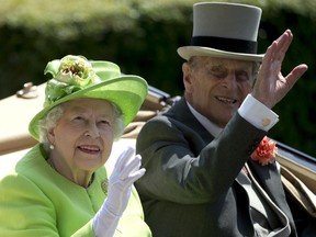 Britain's Queen Elizabeth II, waves to the crowd with Prince Philip at right, as they arrive by open carriage to the parade ring on the first day of the Royal Ascot horse race meeting in Ascot, England, Tuesday, June 20, 2017. (AP Photo/Alastair Grant)