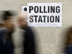 People walk to a polling station for the British general election in Westminster, London, Thursday, June 8, 2017