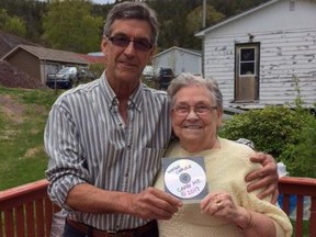 Wayne Chaulk of Buddy Wasisname and the Other Fellers presents Eleanor Parrott with a copy of his band's song "Carry Me," in a handout photo. An 80-year-old woman who planned her own funeral has managed to convince a celebrated Newfoundland band to re-record a song so it would be more appropriate for her eventual farewell. THE CANADIAN PRESS/HO-Wayne Chaulk MANDATORY CREDIT