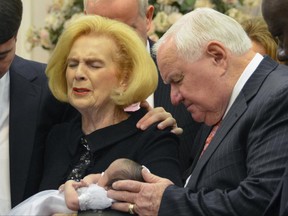 FILE - In this 2012 provided by a former member of the church, Word of Faith Fellowship leader Jane Whaley, center left, holds Jeffrey Cooper's infant daughter, accompanied by her husband, Sam, center right, and others during a ceremony in the church's compound in Spindale, N.C. At least a half-dozen times over two decades, authorities investigated reports that members of a secretive evangelical church were being beaten. And every time, according to former congregants, the orders came down from church leaders: They must lie to protect the sect. (AP Photo)