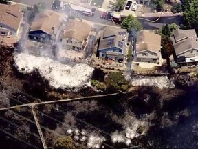 In this image provided courtesy of KTVU-TV, a wildfire burns on a hillside close to homes near the Carquinez Bridge Toll Plaza Thursday, June 22, 2017, in Vallejo, Calif. Firefighters have reported that "multiple" homes are burning and others are at risk as they battle a 4-alarm grass fire in Vallejo. The Vallejo Fire Department says the blaze off Interstate 80 near the Carquinez Bridge has led to the closure of all eastbound lanes on I-80. (Courtesy of KTVU-TV via AP)