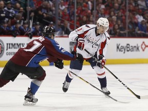 FILE - In this March 29, 2017 file photo Washington Capitals defenseman Dmitry Orlov, right, of Russia, passes the puck as Colorado Avalanche left wing J.T. Compher defends in the second period of an NHL hockey game in Denver. The Washington Capitals have re-signed Orlov to a $30.6 million, six-year deal. (AP Photo/David Zalubowski, File)