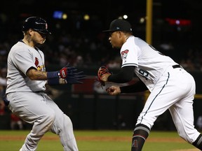 Arizona Diamondbacks' Taijuan Walker, right, reaches over to tag out St. Louis Cardinals' Yadier Molina after an infield grounder during the sixth inning of a baseball game, Tuesday, June 27, 2017, in Phoenix. (AP Photo/Ross D. Franklin)