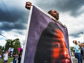 John Thompson, who said he was a close friend of Philando Castile, protests during a demonstration, Sunday, June 18, 2017, in St. Anthony, Minn. The protesters marched against the acquittal of Officer Jeronimo Yanez, was found not guilty of manslaughter for shooting Castile during a traffic stop. (Richard Tsong-Taatarii/Star Tribune via AP)