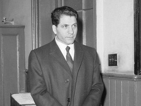 FILE - In this March 24, 1966, file photo, John "Sonny" Franzese waits to be booked at the Elizabeth Street police station in New York, after his arrest on a 43-count gambling indictment. Franzese, a reputed Colombo crime family underboss reported to be the oldest inmate in the federal prison system was released Friday, June 23, 2017, at the age of 100. Newsday reported that Franzese left the Federal Medical Center in Devens, Mass., in a wheelchair just before noon Friday. He was serving a 50-year sentence for bank robbery.. (AP Photo/Anthony Camerano, File)