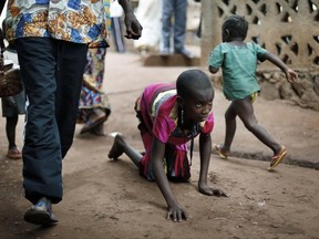 File--In this April 14, 2014 photo, Hamamatou Harouna, 10, crawls to the restroom on the grounds of the Catholic Church where she and hundreds of others found refuge in Carnot, Central African Republic. Human Rights Watch says people with disabilities in Central African Republic are at high risk during attacks and forced displacement, facing neglect in an ongoing humanitarian crisis. (AP Photo/Jerome Delay)