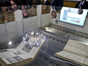 People look at declassified World War II archives presented by Chile's Investigative Police, that unveil Nazi activity in Chile that sought to sabotage Chilean factories and destroy the Panama Canal, at a National Library in Santiago, Chile, Thursday, June 22, 2017. The Police handed the files, four books that cover the period 1937-1944, over to the National Archive. (AP Photo/Esteban Felix)