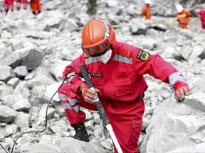 A paramilitary rescuer uses a sensor to check for signs of life in the rubble at the site of a landslide in Xinmo village in Maoxian County in southwestern China's Sichuan Province, Monday, June 26, 2017. Rescue crews were ordered on Monday to evacuate the site of a deadly landslide in southwestern China over concerns of a second landslide, the official Xinhua News Agency reported. (Chinatopix via AP)