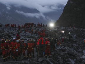 Rescuers work at the accident site after a landslide occurred in the mountain village of Xinmo, Maoxian county,  in southwestern China's Sichuan Province.