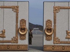 FILE - In this Monday, April 15, 2013, file photo, a North Korean soldier guarding the entrance to Pyongyang's Kumsusan mausoleum, where the bodies of the late leaders Kim Il Sung and Kim Jong Il lie embalmed, looks back through the doors of the main gate. The death last week of American student Otto Warmbier, who fell into a coma after being arrested in North Korea, has raised questions about whether his tour agency was adequately prepared for its trips into the hard-line communist state. The Young Pioneer Tours agency built up a business attracting young travelers with cut-rate, hard-partying adventures into one of the world's most isolated countries. (AP Photo/David Guttenfelder, File)