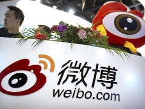In this April 27, 2017 photo, staff members wait for visitors at a booth for Chinese microblogging website Sina Weibo at the Global Mobile Internet Conference (GMIC) in Beijing. Three popular Chinese internet services have been ordered Thursday, June 22, 2017, to stop streaming video after censors complained it contained improper comments about sensitive issues. The move prompted a sell-off in the U.S.-trade shares of Sina Corp. and its microblog service, Sina Weibo. (AP Photo/Mark Schiefelbein)
