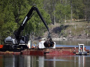 FILE- In this May 7, 2015 file photo, crews perform dredging work along the upper Hudson River in Waterford, N.Y. Dredging crews left the Hudson River two years ago, but criticism of the $1.7 billion cleanup is bubbling up again. Advocates who want the Environmental Protection Agency to order crews back on the river are expected in Poughkeepsie on Wednesday, June 28, 2017.  The EPA is holding a public hearing on its five-year review of the Superfund project. (AP Photo/Mike Groll, File)