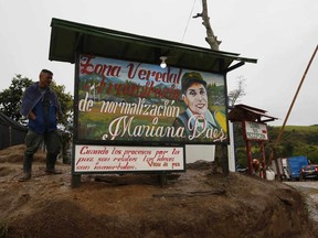 A rebel of the Revolutionary Armed Forces of Colombia, FARC, stands guard at the Mariana Paez demobilization zone, one of many rural camps where rebel fighters are making their transition to civilian life, in Buenavista, Colombia, Monday, June 26, 2017. On Tuesday, Colombia's President Juan Manuel Santos and the FARC's top commander Timochenko will meet here to commemorate the completion of the disarmament process. (AP Photo/Fernando Vergara)