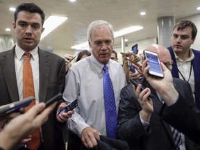 FILE - In this June 22, 2017, file photo, Sen. Ron Johnson, R-Wis., walks through a group of reporters after Republicans released their long-awaited bill to scuttle much of President Barack Obama's Affordable Care Act at the Capitol in Washington. Conservatives and liberals alike in Wisconsin both see hope in Johnson's steadfast refusal to back the current version of the GOP Senate health care bill. (AP Photo/J. Scott Applewhite, File)