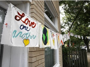Painted cloth flags including one saying "Love One Another" are strung across a store along Mt. Vernon Ave. in Alexandria, Va.