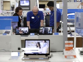 In this Tuesday, May 23, 2017, photo, employees assist a customer, at left, with a computer at Best Buy in Cary, N.C. On Friday, June 30, 2017, the Commerce Department issues its May report on consumer spending. (AP Photo/Gerry Broome)