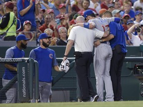 Chicago Cubs third baseman Kris Bryant (17) is helped off the field by trainers after he was injured during the fifth inning of the team's baseball game against the Washington Nationals, Wednesday, June 28, 2017, in Washington. (AP Photo/Nick Wass)