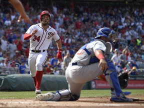 Washington Nationals' Bryce Harper runs towards home to score on a hit by Ryan Zimmerman AS Chicago Cubs catcher Willson Contreras, right, waits for the throw during the first inning of a baseball game, Thursday, June 29, 2017, in Washington. (AP Photo/Nick Wass)