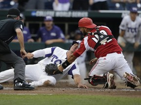 TCU's Josh Watson (7) is safe at home before the tag by Louisville catcher Colby Fitch (42) during the second inning of an NCAA College World Series baseball game in Omaha, Neb., Thursday, June 22, 2017. (AP Photo/Nati Harnik)