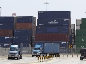 Containers are stacked up as trucks drive by at Port of Elizabeth, which reports say has had trouble with a cyberattack, Thursday, June 29, 2017, in Elizabeth, N.J. The dramatic data-scrambling attack that hit computers around the world Tuesday appears to be contained. But with the damage and disruption still coming into focus, security experts worry the sudden explosion of malicious software may have been more sinister than a criminally minded shakedown of computer users. (AP Photo/Julio Cortez)