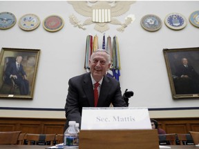 Defense Secretary Jim Mattis smiles at photographers before he testifies at a House Armed Services Committee hearing on the defense budget for the 2018 budget year.