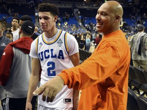 FILE - In this Nov. 20, 2016, file photo, UCLA's Lonzo Ball (2) walks by his father LaVar Ball, right, to greet family members after UCLA defeated Long Beach State in an NCAA college basketball game in Los Angeles.  By now the entire basketball world knows Lonzo Ball is a singular talent with a unique parent.  (AP Photo/Michael Owen Baker, File)