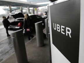 In this March 15, 2017 photo, a sign marks a pick-up point for the Uber car service at LaGuardia Airport in New York.