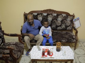 Sudanese activist Tayeb Ibrahim, who had worked to expose Sudanese abuses in the volatile South Kordofan province and hopes to see family living in the U.S. state of Iowa, watches television with his son Mohammed, in Cairo, Egypt, Wednesday, June 28, 2017. Dozens of Sudanese activists living in Egypt as refugees, many of whom fled fundamentalist Islamic militias and were close to approval for resettlement in the United States, now face legal limbo in Egypt after the Supreme Court partially reinstated President Donald Trump's travel ban. (AP Photo/Amr Nabil)