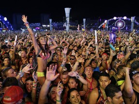 FILE - In this June 21, 2014 file photo, carnival goers dance to music by Krewella at the Electric Daisy Carnival in Las Vegas. Organizers of the largest music festival in North America are reminding attendees to report any suspicious activity they might witness during the event that begins Friday, June 16, in Las Vegas, less than a month after a deadly terrorist attack struck a concert in England. (AP Photo/John Locher, File)