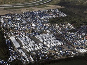 FILE - In this Monday, Oct. 17, 2016 file photo showing an aerial view of a makeshift migrant camp near Calais, France. A French court has ruled against creating a new center for migrants in the western port city of Calais but says they should have access to water, showers and toilets, services the city's mayor is refusing to provide, Tuesday, June 27, 2017. (AP Photo/Thibault Camus, File)