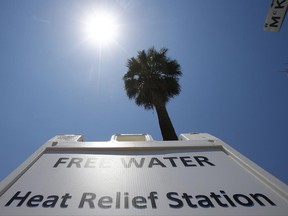 A Salvation Army hydration station sign gets hit by the midday sun as temperatures climb to near-record highs, Monday, June 19, 2017, in Phoenix. (AP Photo/Ross D. Franklin)