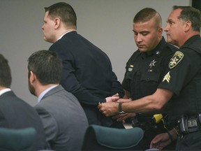Washington County Sheriff's Officers place handcuffs on Matthew Slocum after he was found guilty on all counts in his triple murder retrial on Tuesday, June 20, 2017, at Washington County Court in Fort Edward, N.Y. Slocum was found guilty on all counts Tuesday in his retrial for the 2011 shotgun slayings of his mother, stepfather and stepbrother in their rural upstate New York home.(Shawn LaChapelle /The Post-Star via AP, Pool)