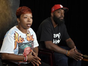 FILE - In this Sept. 27, 2014, file photo, the parents of Michael Brown, Lezley McSpadden, left, and Michael Brown Sr., sit for an interview with The Associated Press in Washington. The city attorney in Ferguson, Missouri, said Friday, June 23, 2017, that the city's insurance company paid $1.5 million to settle a lawsuit filed by the family of Michael Brown. (AP Photo/Susan Walsh, File)