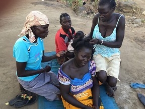 Women getting their hair down at a refugee camp.  Bidibidi, Uganda, April 13, 2017 — South Sudanese women take a break from long days of queuing for food and water and caring for large numbers of children in what has become the largest refugee camp in the world.