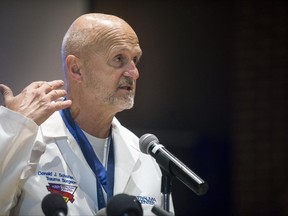 Hurley Trauma Surgeon, Dr. Donald Scholten, M.D. points to his neck to illustrate where Lt. Jeff Neville was stabbed during a press conference Friday, June 23, 2017, at the Merliss Brown Auditorium, in Flint, Mich. The Flint, Michigan, airport officer stabbed in the neck during what authorities are investigating as a terrorist act is recovering well from a 12-inch "slash" that caused significant bleeding but spared major arteries and a nerve by "millimeters," Scholten said Friday. (Shannon Millard /The Flint Journal-MLive.com via AP)