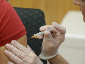 FILE - In this Friday, Sept. 16, 2016 file photo, a woman receives a flu vaccine shot at a community fair in Brownsville, Texas. On Wednesday, June 21, 2017, U.S. health officials released new estimates showing the previous winter's flu vaccine was ineffective in protecting older Americans against the illness, even though the vaccine was well-matched to the flu bugs going around. (Jason Hoekema/The Brownsville Herald via AP)