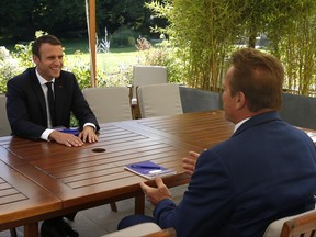 French President Emmanuel Macron, left, speaks with former US actor and founder of the R20 climate action group Arnold Schwarzenegger Friday, June 23, 2017 at the Elysee Palace in Paris. (Geoffroy van der Hasselt, Pool via AP)