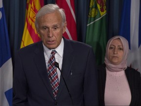 Rania Tfaily, Hassan Diab's wife, looks on as lawyer Donald Bayne responds to a question during a news conference in Ottawa, Wednesday June 21, 2017. THE CANADIAN PRESS/Adrian Wyld