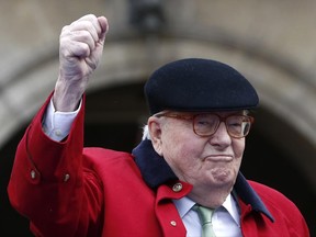FILE - In this May 1, 2017 file photo, former far-right National Front party leader Jean-Marie Le Pen clenches his fist at the statue of Joan of Arc, in Paris. France's far-right National Front has refused Tuesday June 20 2017 to let Jean-Marie Le Pen, the party's co-founder, attend a meeting of its political bureau, blocking him at the gate on the day of his 89th birthday. (AP Photo/Kamil Zihnioglu, File)