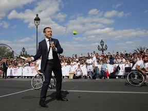 French President Emmanuel Macron plays tennis on the Pont Alexandre III in Paris, Saturday June 24, 2017. The French capital is transformed into a giant Olympic park to celebrate International Olympic Day with a variety of sporting events for the public across the city during two days as the city bids to host the 2024 Olympic and Paralympic Games.(Jean Paul Pelissier, Pool Photo via AP)