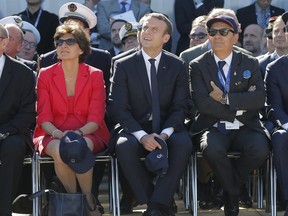 French President Emmanuel Macron, center, French defense minister Sylvie Goulard and Dassault Aviation CEO Eric Trappier, right, watch demonstration flights as part of the Paris Air Show in Le Bourget, north of Paris, Monday, June 19, 2017. Macron landed Monday at the Bourget airfield in an Airbus A400-M military transport plane to launch the aviation showcase, where the latest Boeing and Airbus passenger jets will vie for attention with a F-35 warplane, drones and other and high-tech hardware. (AP Photo/Michel Euler, Pool)