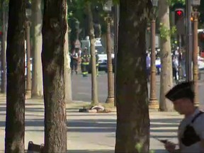 A person is seen on the ground  as a police officer is seen in the foreground on the  Champs Elysees avenue  in Paris, France, Monday, June 19, 2017. France's anti-terrorism prosecutor has opened an investigation into the ramming of a police vehicle on Paris' Champs-Elysees avenue. Authorities say a driver has rammed his car into a police vehicle in the Champs-Elysees shopping district. They say he has been arrested after being injured in a subsequent apparent clash with police.  The condition of the person on the ground is not known. (AP Photo)