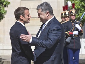 French President Emmanuel Macron, left, welcomes Ukrainian President Petro Poroshenko at the Elysee Palace, in Paris, France, Monday, June 26, 2017. French President Emmanuel Macron meets Ukrainian President Petro Poroshenko to discuss the Ukrainian crisis. (AP Photo/Michel Euler)