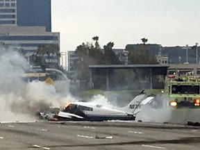 Flame and smoke erupt from a twin-engine prop jet after it crashed on Interstate 405, just short of the runway at John Wayne Orange County Airport, in Costa Mesa, Calif., Friday, June 30, 2017. Two people were injured in the small plane crash and taken to the hospital with traumatic injuries.