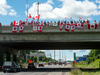 People fly Canadian flags an overpass during the funeral procession for Nazzareno Tassone in his hometown of Niagara Falls, Ont., June 21, 2017.
