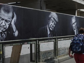 A poster with the portraits of Turkish President, Recep Tayyip Erdogan, left, US President Donald Trump, center, and Russian President Vladimir Putin, hangs on the Warschauer  Bruecke, Warsaw Bridge,  in Berlin, Germany,  Tuesday, June 27, 2017. The poster is part of an advertisement campaign of a drinks manufacturer. (Jens Kalaene/dpa via AP)